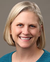 Jacquelyn O’Banion MD, MSc A smiling woman with blonde hair wearing a teal shirt.