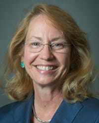 Cynthia Toth, MD A smiling woman with shoulder-length blonde hair and glasses wearing a blue blazer.